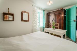 ein Schlafzimmer mit einem Bett und einem Tisch und einem Fenster in der Unterkunft Appart centre La Salvetat Agout in La Salvetat