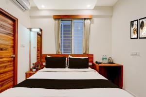 um quarto com uma cama grande e uma janela em Super Townhouse Marathahalli KLM Fashion Mall Formerly Hotel Avenue em Bangalore mais 23 fotografias