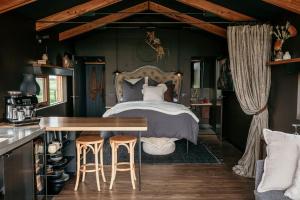 1 dormitorio con cama, mesa y taburetes en Basalt Wines Retreat, en Killarney