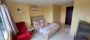 a small bedroom with a bed and a chair at RELAX HOTEL in Sungai Petani