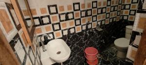 Un baño con lavabo e inodoro en Royal Kashi Lodge, en Prayagraj