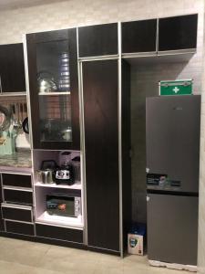 una cucina con armadietti bianchi e neri e un frigorifero di Goshen Arena Luxury Family and Business Apartment a Owerri