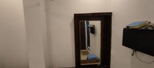 un espejo en una pared junto a una TV en Royal Kashi Lodge, en Prayagraj