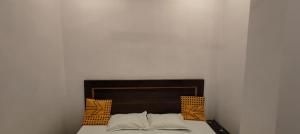 una cama en una habitación con una pared blanca en Royal Kashi Lodge, en Prayagraj 28 fotos más