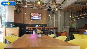 uma mesa de madeira em um restaurante com cadeiras amarelas em An Hotel Jakarta em Jacarta