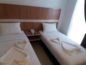 duas camas com lençóis brancos com corações em Sakura Manado em Manado mais 60 fotografias