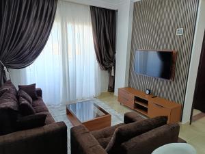 a living room with two couches and a flat screen tv at ParadiseHotel in Banī Ghālib