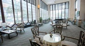 um restaurante com mesas e cadeiras e grandes janelas em Fortune International Hotel em Xingyin Wanfenglin Airport