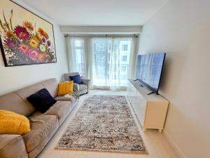 a living room with a couch and a flat screen tv at 2 bedroom heart of Central Surrey in Surrey