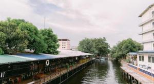 a body of water with buildings and a river at Rimnam Hotel Suk Sawat 70 in Ban Khru Nok