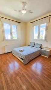 a bedroom with a bed and a ceiling fan at Townbeach Villa with Private Pool in Voroklini +14 photos