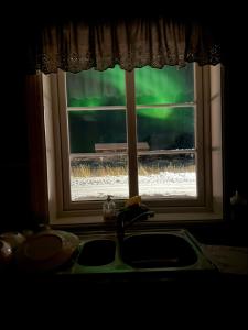 Un fregadero de cocina con una ventana por la que pasa un tren. en BanPim Beachside Lofoten, en Ramberg