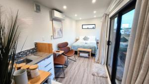 a small room with a bed and a table and chairs at Kawatiri Palms in Westport