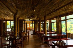 a dining room with tables and chairs and windows at Muong Hoa River View Hotel in Sa Pa