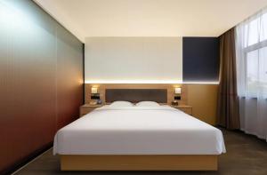 Postel nebo postele na pokoji v ubytování Huanyang Hotel Qingdao Chengyang Youth Football Stadium Branch