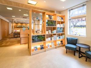 佐贺市佐贺康福特酒店的图书馆里有书架、桌子和椅子