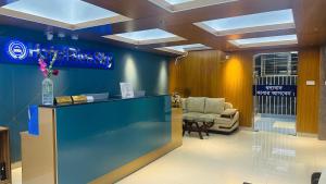 a lobby with a reception desk and a chair at Hotel Blue Sky Mirpur in Dhaka