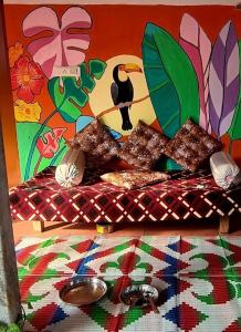 オーロヴィルにあるSPIDEY's PITSTOPの壁に絵が飾られたベッドのある寝室