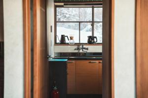 a kitchen with a sink and a window at Karabiner House Myoko in Myoko