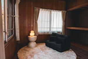 a living room with a chair and a window at Karabiner House Myoko in Myoko