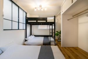 a bedroom with two beds and a loft bed at epilogue hotel 302 in Fukuoka