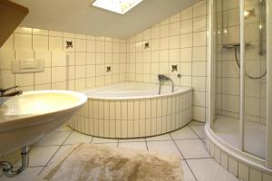 韦耶达Apartments in Wieda的带浴缸、淋浴和水槽的浴室