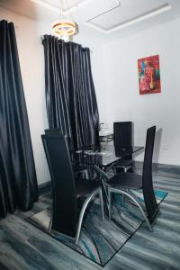 a dining room with a table and black chairs at Shepherd Spring Apartments in Gbogije