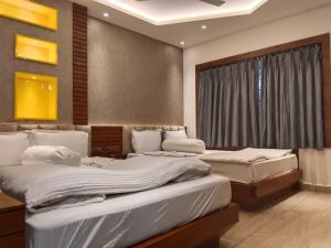 una stanza con tre letti e una finestra di Krishti Resorts a Tajpur Altre 32 foto