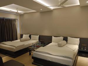 a room with two beds and a table in it at Krishti Resorts in Tajpur +31 photos