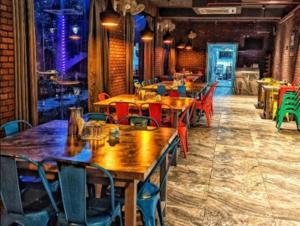a dining room with wooden tables and chairs at Krishti Resorts in Tajpur