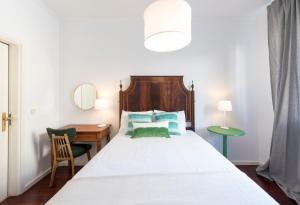 Un dormitorio con una cama con un escritorio y una silla. en LovelyStay - Porto Beach Apartment, en Oporto
