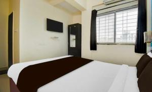 コルカタにあるHotel O Narayana RN Tagore Hospital Formerly Lantern Guest Houseの窓のある大きなベッドのある寝室