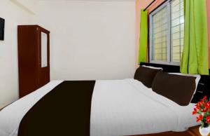 コルカタにあるHotel O Narayana RN Tagore Hospital Formerly Lantern Guest Houseの大きな白いベッドと窓のある寝室