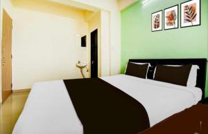 コルカタにあるHotel O Narayana RN Tagore Hospital Formerly Lantern Guest Houseのベッドルーム(白い大型ベッド、黒い枕付)