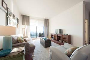 Una sala de estar con dos sofás y un televisor. en LovelyStay - Porto Beach Apartment, en Oporto