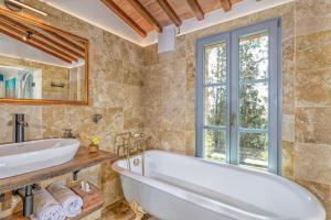 a bathroom with a tub and a sink and a window at Villa MonteLandi in Montalcino