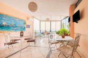 Una habitación con sillas y mesas y un cuadro en la pared. en Bed n breakfast Paradise, en Melendugno