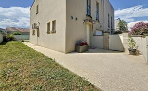 einen Gehweg neben einem Haus mit einem Zaun in der Unterkunft La Rose des Vents in Valence