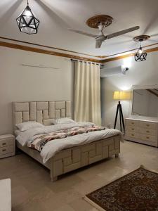 a bedroom with a large bed and a ceiling fan at SereneNest in Islamabad