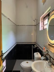 a bathroom with a toilet and a sink and a mirror at SereneNest in Islamabad