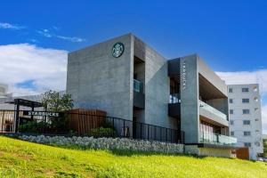 a building with a clock on the side of it at 本部町 最大12名宿泊可 無料駐車場2台付き 家族 グループに最適 Terrace Motobu in Motobu
