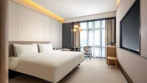 a hotel room with a bed and a tv at Holiday Inn Express Guangzhou Baiyun Airport T2 by IHG in Huadu