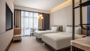 a hotel room with two beds and a desk at Holiday Inn Express Guangzhou Baiyun Airport T2 by IHG in Huadu