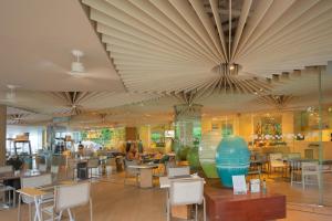 a restaurant with tables and chairs and a large ceiling at KingBed Beachfront-Pool Condo & Kitchen,Playground,TV,Wifi in Jomtien Beach