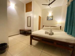 Un dormitorio con una cama con un animal de peluche encima. en Villa Shakti - TIE, en Pondicherry 44 fotos más