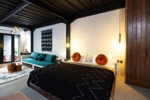 a bedroom with a large bed and a couch at Warehouse Loft - Chic industrial aesthetic loft in Dalung