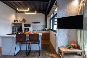 a kitchen with two chairs and a counter in a room at Warehouse Loft - Chic industrial aesthetic loft in Dalung