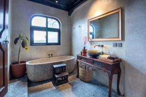a bathroom with a tub and a sink and a mirror at Warehouse Loft - Chic industrial aesthetic loft in Dalung