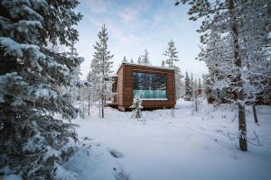 a log cabin in the woods in the snow at Aurora Hill Resort, Rovaniemi in Rovaniemi