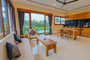 a living room filled with furniture and a table at Griya Mandara Ubud Villa in Ubud